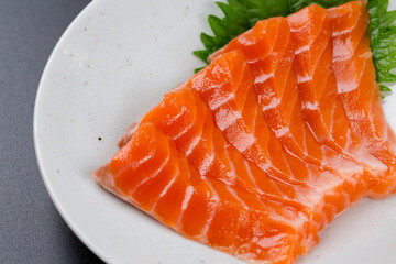 皿に盛られたサーモンのお刺身 黒背景