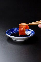 皿に盛られたサーモンのお刺身 黒背景