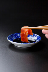 皿に盛られたサーモンのお刺身 黒背景