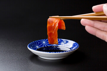 皿に盛られたサーモンのお刺身 黒背景