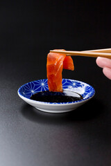 皿に盛られたサーモンのお刺身 黒背景