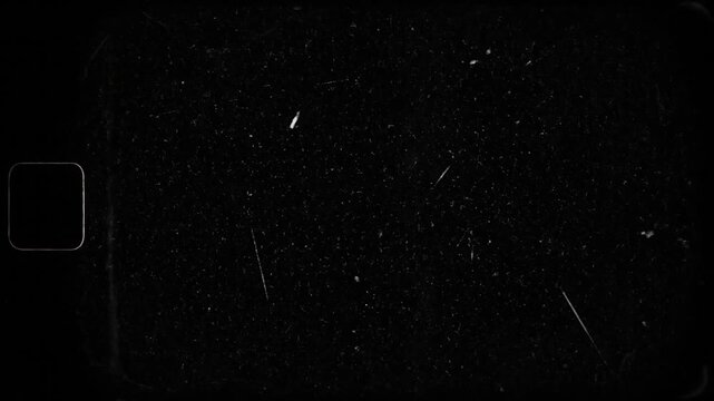 A textured, dark, vintage film frame with white imperfections and a single rounded rectangle