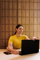 Young woman engages with her laptop in a bright and modern workspace during the afternoon,...