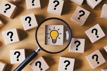 Magnifying glass over lightbulb idea surrounded by question mark blocks