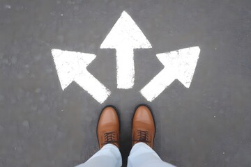 Person s feet standing at three way arrow intersection on road