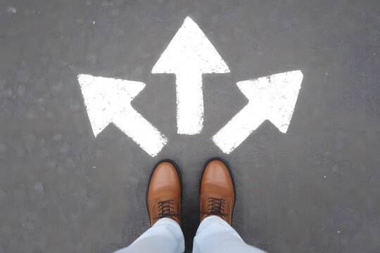 Person s feet standing at three way arrow intersection on road