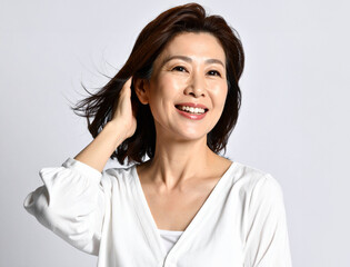 笑顔で髪を触る中年女性