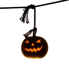 Glowing jack o lantern hanging from a rope against a dark on white background