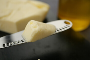 Spreading creamy butter on a knife in a kitchen setting