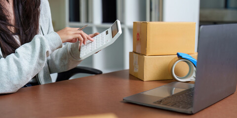 E-commerce: Individual calculating costs while managing packages