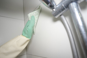 Cleaning a shower wall with care and attention