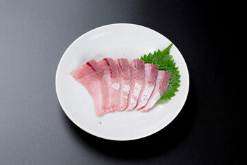 皿に盛られたブリのお刺身 黒背景