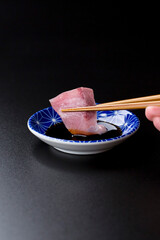 皿に盛られたブリのお刺身 黒背景