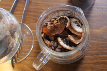 Dried fruits and coffee beans in a glass jar on wooden table