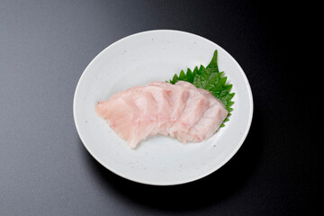 皿に盛られたサワラのお刺身 黒背景