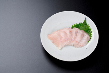 皿に盛られたサワラのお刺身 黒背景