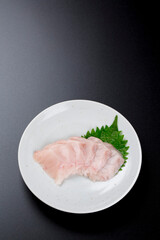 皿に盛られたサワラのお刺身 黒背景