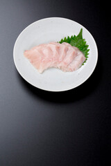 皿に盛られたサワラのお刺身 黒背景