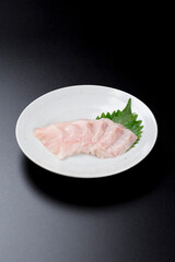 皿に盛られたサワラのお刺身 黒背景