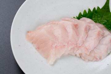 皿に盛られたサワラのお刺身 黒背景