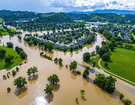Aerial view of a flooded suburban community, river overflowing