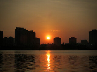 Golden Sun Over Quiet Lake: Minimal Skyline and Gentle Ripples on West Lake in Hanoi, Vietnam