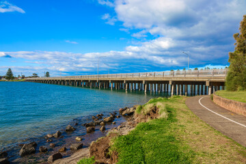 Obraz premium A serene coastal lagoon between Wollongong and Shellharbour, perfect for kayaking, fishing, birdwatching, and sunset walks — where nature, sky, and sea meet in harmony.
