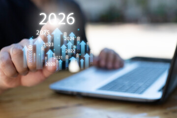 Businessman drawing digital growth arrows and bar graph with 2026 target. Futuristic concept for business goals, technology strategy, data-driven planning, success and innovation.