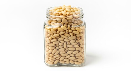 A glass jar filled with pine nuts on a white background