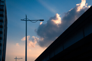 Obraz premium Urban streetlight silhouette against dramatic sunset sky