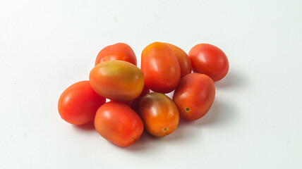 a pile of several cherry tomatoes on a white background

