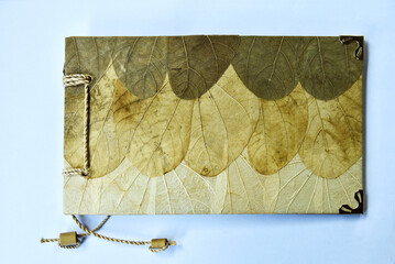 an album whose cover is made of dry leaves or brown plant fibers