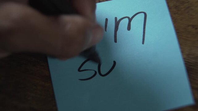 Hand writing an apology note with a broken heart