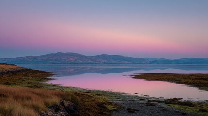 Obraz premium Tranquil Sunset Over Calm Water with Reflective Shoreline and Mountains in Twilight