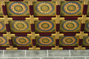 Obraz premium the ceiling ornament of a Chinese architectural building is shaped like a box with a circle inside it in gold.