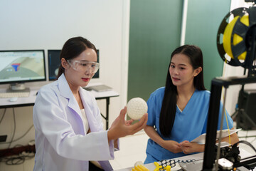 Researchers are working with a 3D printer to print clear, white plastic models using cutting-edge,...