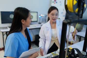 Researchers are working with a 3D printer to print clear, white plastic models using cutting-edge,...