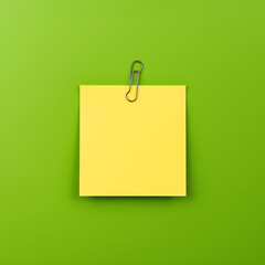 Image of sticky notes paper with a paperclip, set against a green screen background, featuring one sticky note that has empty space.