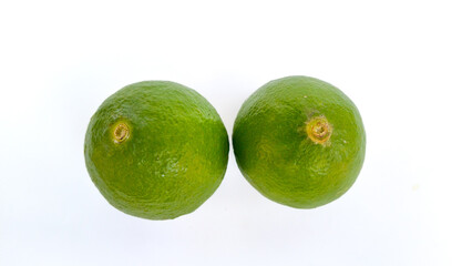 Two fresh green limes on white background, tropical citrus fruit rich in vitamin C and antioxidants