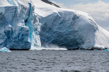 Telephoto of a giant chunk of ice calving off an ice sheet. Graham Passage, near Charlotte Bay, on...