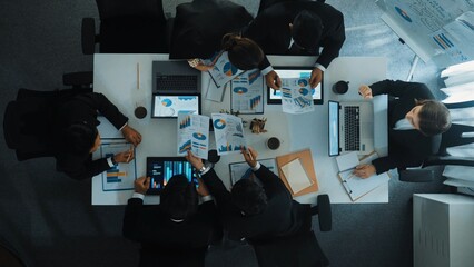 Top down aerial view of smart business woman handing out financial document to diverse team while...