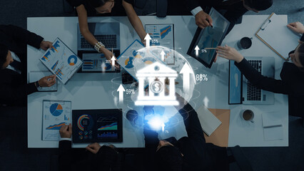 A diverse business team collaborates in an office setting, examining financial data represented by charts and graphics, emphasizing modern digital banking concepts. Trope