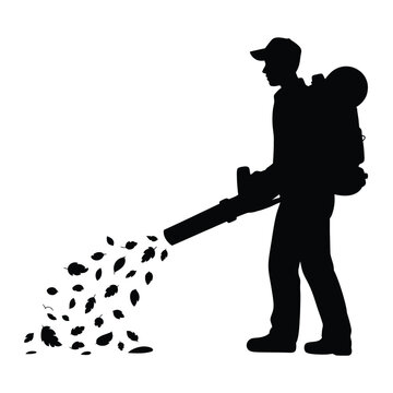 Silhouette of a person using a leaf blower to clear leaves