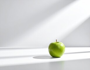 Single green apple on white surface, sunbeams