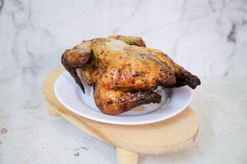 Roasted chicken whole on white plate	
