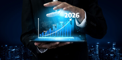 A male executive presents a digital graph on a tablet, showcasing business growth projections from 2023 to 2026 against a city backdrop, symbolizing future success. Tessel