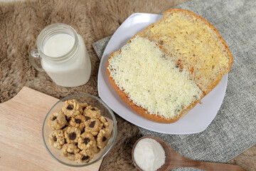 Bread with cheese, sweetened condensed milk, and butter. With white milk and snack on a table for breakfast	
