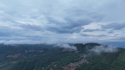 Green mountain valley landscape in Kunming,Mountains and clouds in Kunming, Yunnan,Natural mountain scenery in Kunming,Kunming valley surrounded by green hills,Misty mountain forest in Kunming