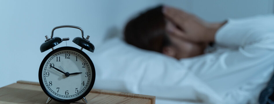 Young woman sleepless during night time on the bed.