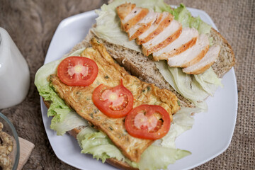 Big breakfast, bread, chicken slice, tomato, lettuce, smoked beef, egg, salad with milk. Bread sandwich fresh and healthy food meal lunch dinner breakfast slices of sandwiches.
